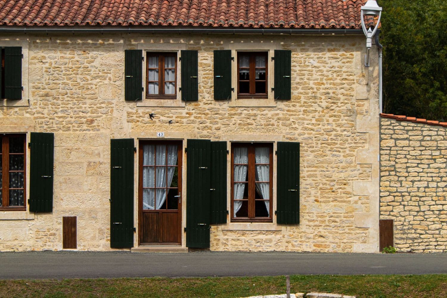 Maison de village en pierre, aux volets verts