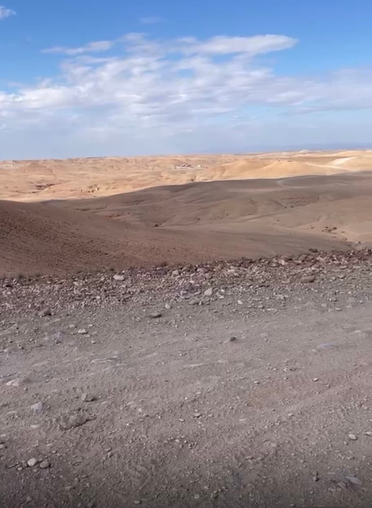 Collines désertiques sous un ciel nuageux